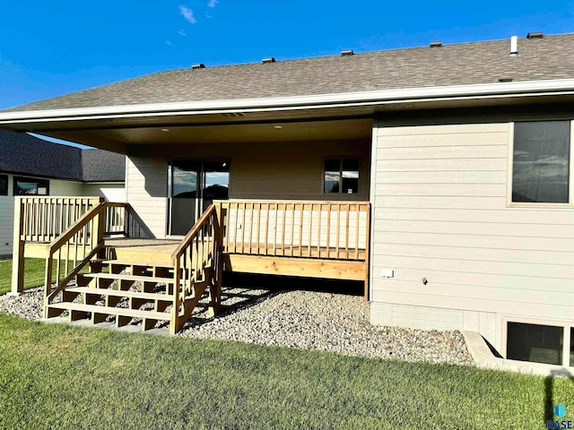 rear view of property with a lawn and a wooden deck