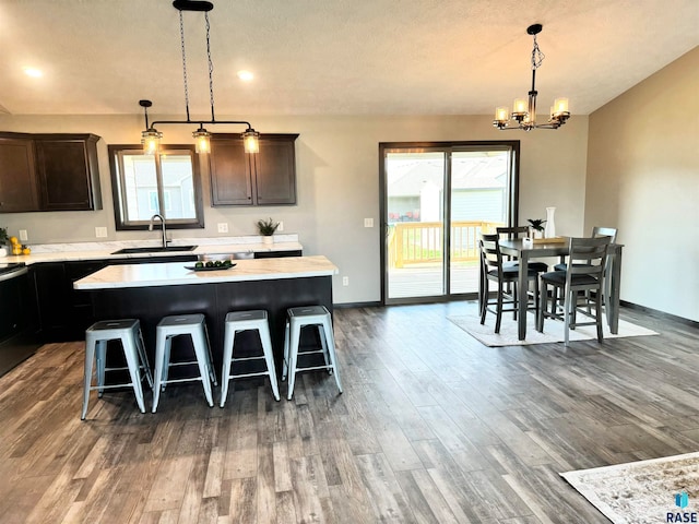 kitchen featuring a breakfast bar, a center island, dark hardwood / wood-style floors, and sink