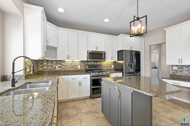 kitchen featuring appliances with stainless steel finishes, white cabinets, sink, and dark stone counters