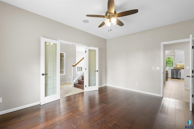 spare room featuring french doors, ceiling fan, and wood-type flooring