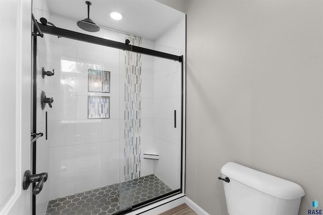 bathroom with toilet and a shower with shower door