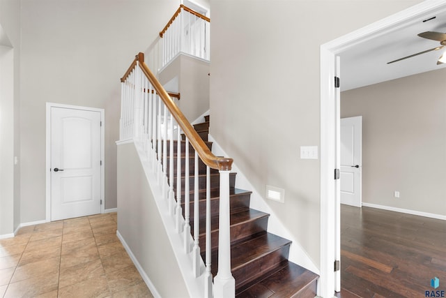 stairway with hardwood / wood-style flooring and ceiling fan