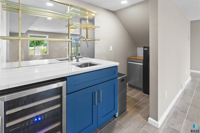 bar featuring sink, beverage cooler, and stainless steel refrigerator