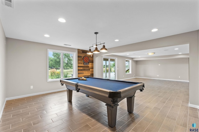 game room with a wealth of natural light, hardwood / wood-style flooring, and billiards