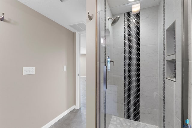 bathroom with a shower with door and tile patterned flooring