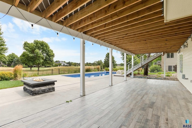 view of patio / terrace with an outdoor fire pit and a swimming pool side deck