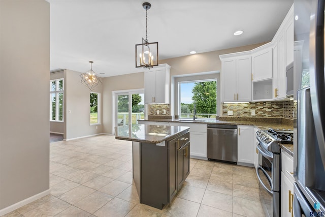 kitchen with a center island, appliances with stainless steel finishes, white cabinets, and tasteful backsplash