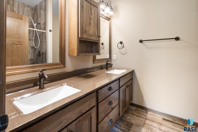 bathroom featuring vanity, wood-type flooring, and walk in shower