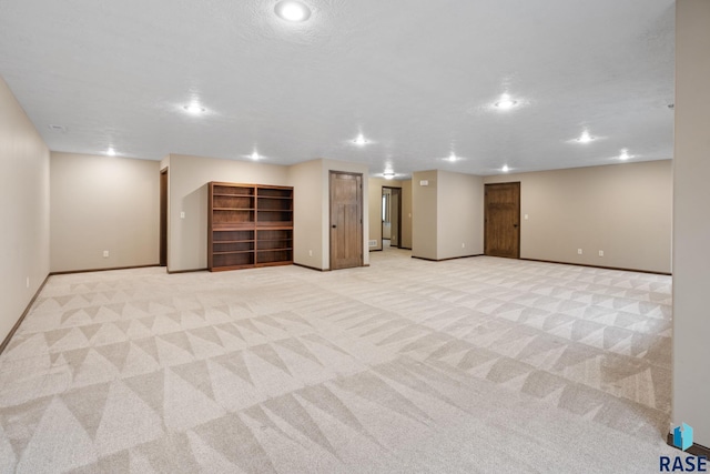 basement featuring light colored carpet and a textured ceiling