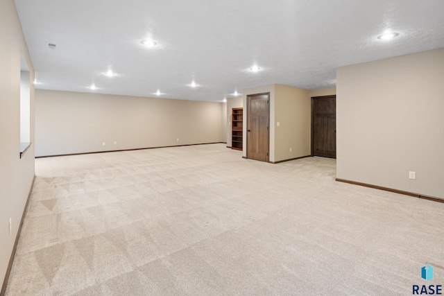 basement with light colored carpet and a textured ceiling