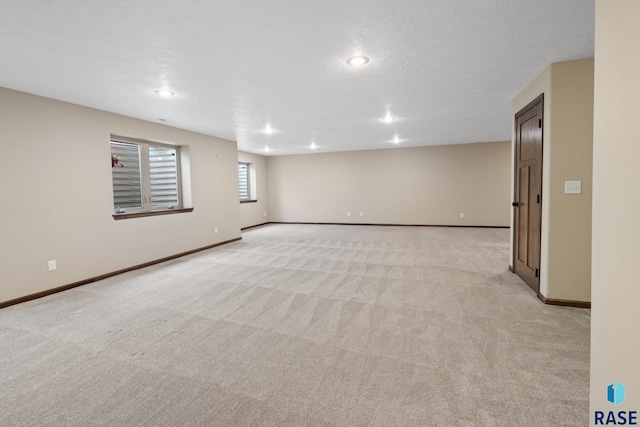 basement with light colored carpet and a textured ceiling