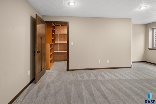 carpeted empty room featuring a textured ceiling