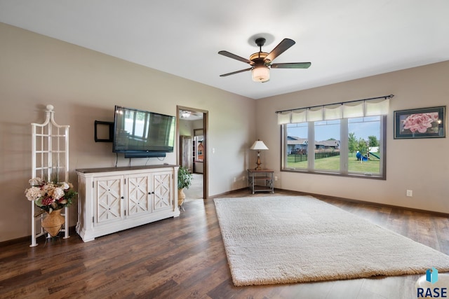 living area featuring dark wood-type flooring and ceiling fan