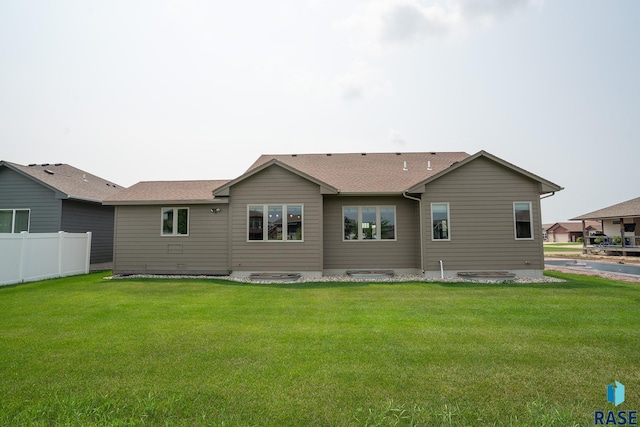 rear view of property featuring a lawn