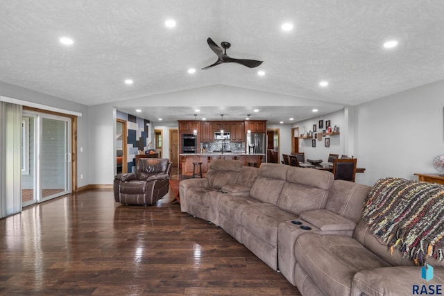 living room featuring lofted ceiling, ceiling fan, a textured ceiling, and dark hardwood / wood-style flooring