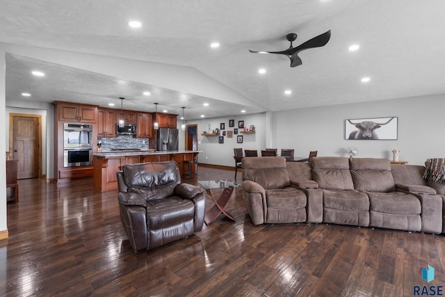 living room featuring dark wood-type flooring, ceiling fan, a textured ceiling, and vaulted ceiling