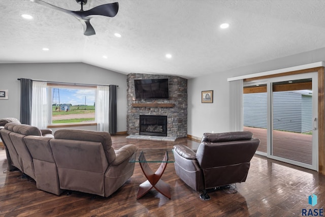 living room featuring a fireplace, a textured ceiling, dark hardwood / wood-style flooring, ceiling fan, and vaulted ceiling