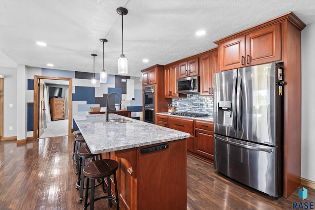 kitchen featuring a spacious island, stainless steel appliances, dark hardwood / wood-style flooring, and hanging light fixtures