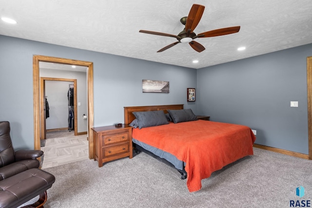 bedroom featuring ceiling fan, a textured ceiling, and light colored carpet