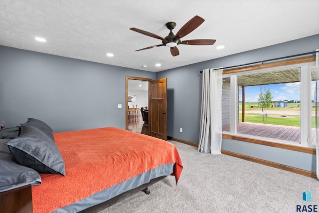 carpeted bedroom featuring a textured ceiling and ceiling fan