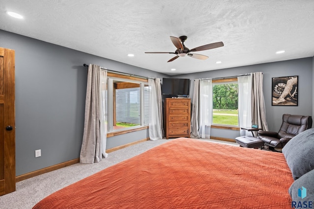 unfurnished bedroom with ceiling fan, light carpet, and a textured ceiling