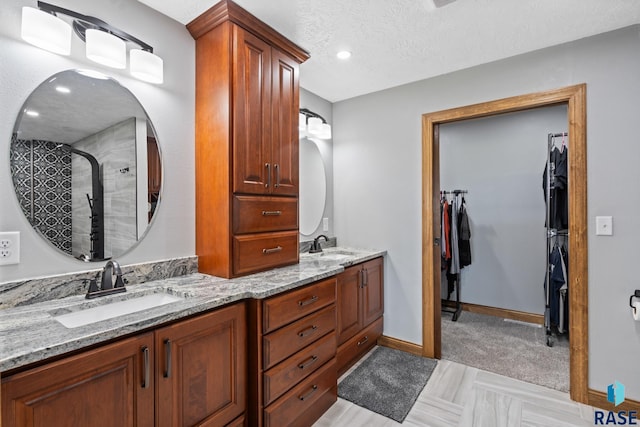 bathroom with vanity, a textured ceiling, and an enclosed shower