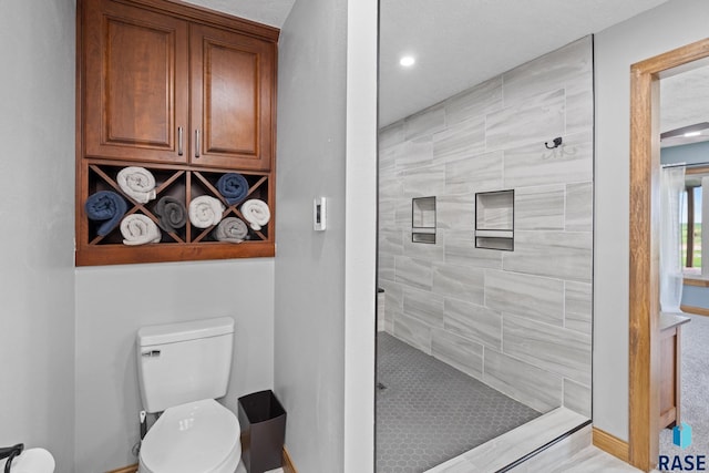 bathroom with tiled shower and toilet