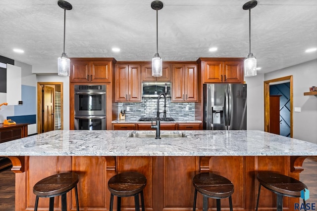 kitchen featuring a spacious island, stainless steel appliances, tasteful backsplash, and hanging light fixtures