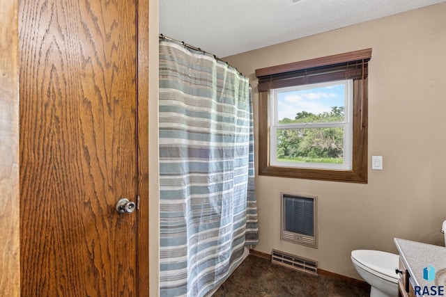 bathroom featuring vanity, a textured ceiling, heating unit, and toilet