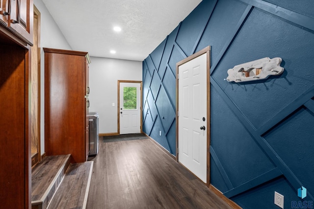 doorway featuring washer / clothes dryer, vaulted ceiling, and dark hardwood / wood-style flooring