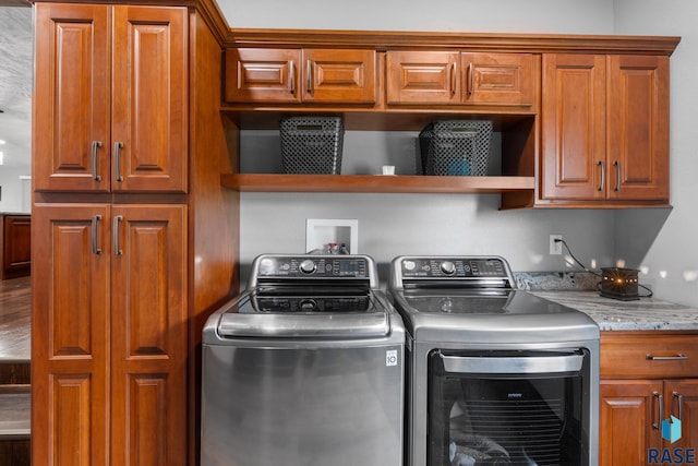 washroom featuring washer and dryer and cabinets