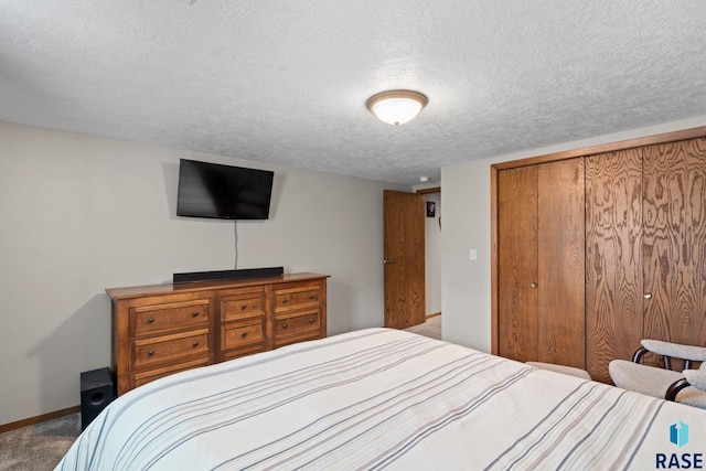 bedroom featuring carpet, a textured ceiling, and a closet