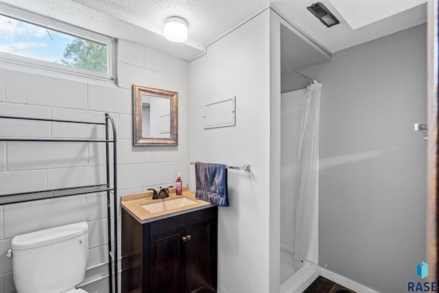 bathroom with vanity, toilet, a textured ceiling, and a shower with shower curtain