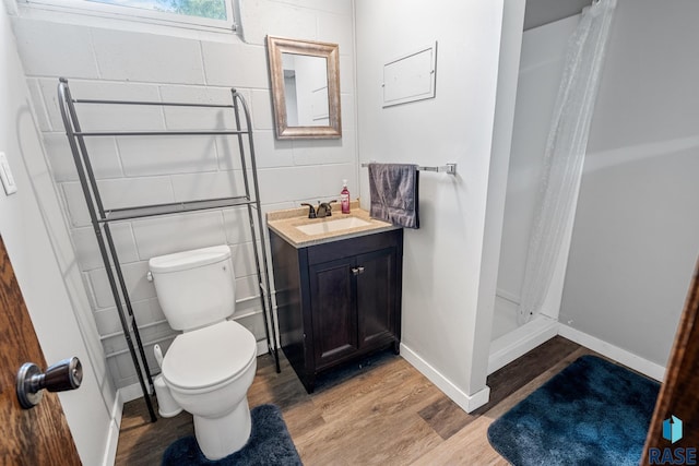 bathroom with toilet, a shower with curtain, vanity, and wood-type flooring