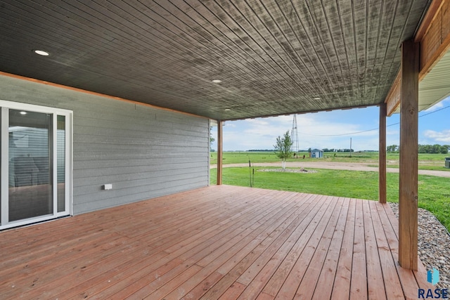 wooden terrace with a rural view and a lawn