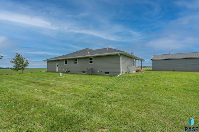 back of house with central AC and a lawn