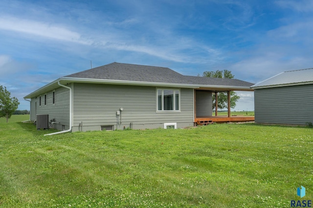 back of property featuring central AC and a lawn