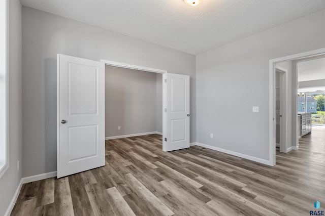 unfurnished bedroom featuring hardwood / wood-style floors and a textured ceiling