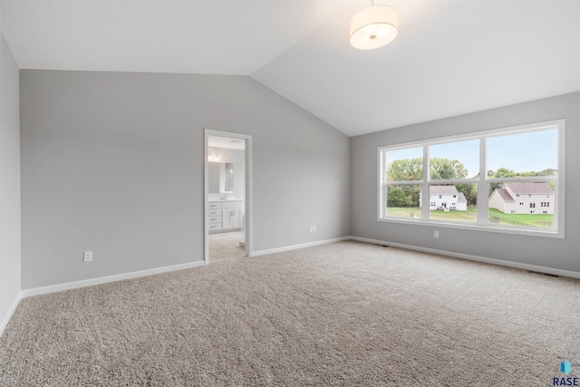 carpeted spare room featuring lofted ceiling