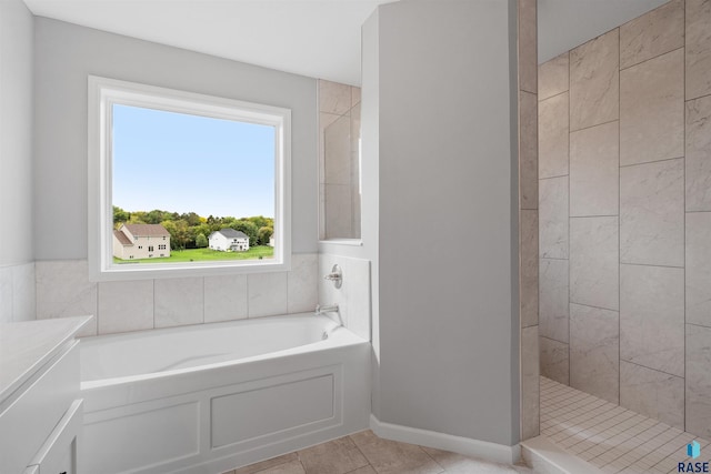 bathroom with tile patterned floors and shower with separate bathtub