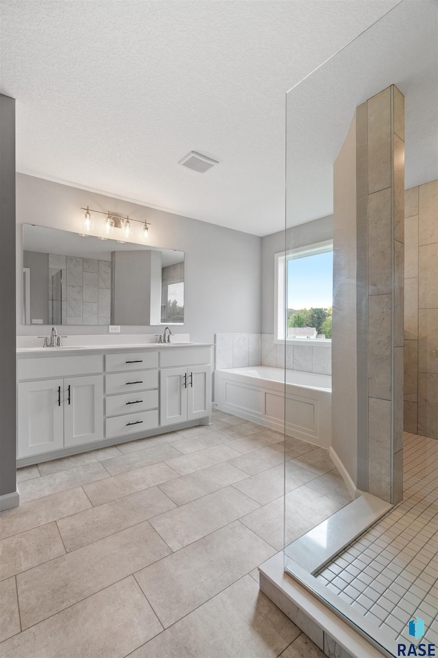 bathroom with vanity, a textured ceiling, separate shower and tub, and tile patterned flooring