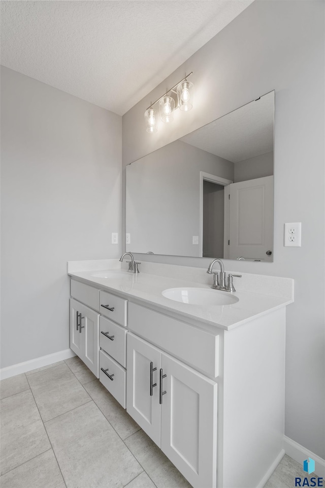 bathroom with vanity, a textured ceiling, and tile patterned flooring