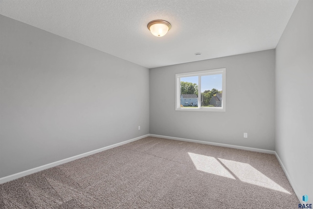 unfurnished room with a textured ceiling and carpet floors