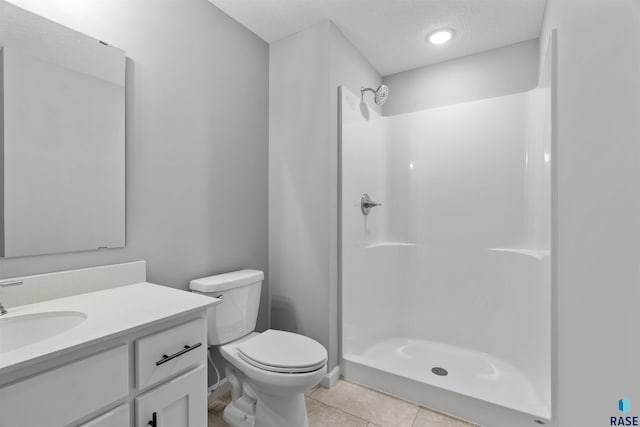 bathroom with vanity, toilet, a shower, and tile patterned flooring