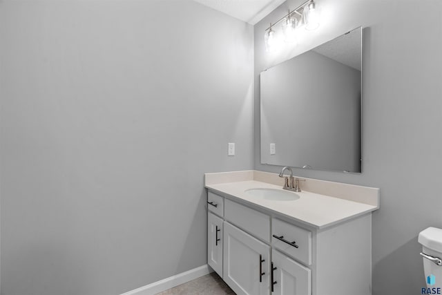 bathroom featuring toilet, a textured ceiling, and vanity