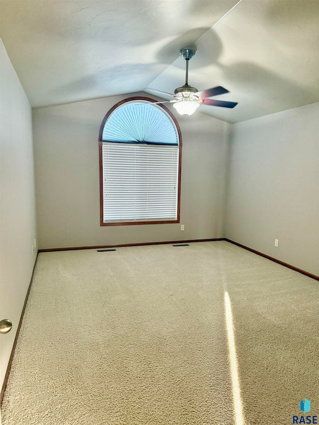 spare room featuring lofted ceiling, carpet flooring, and ceiling fan