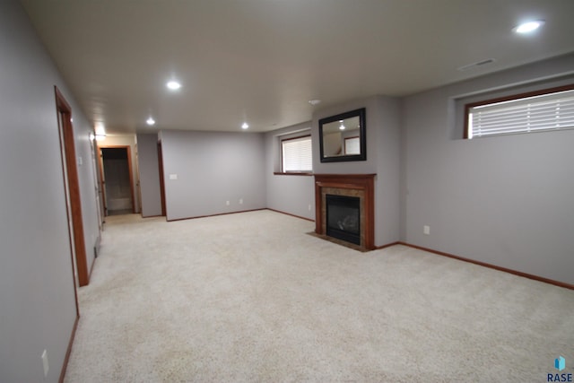 basement with light carpet and a fireplace