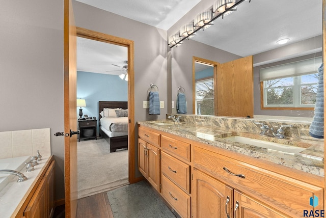 bathroom featuring vanity, wood-type flooring, a tub, and ceiling fan