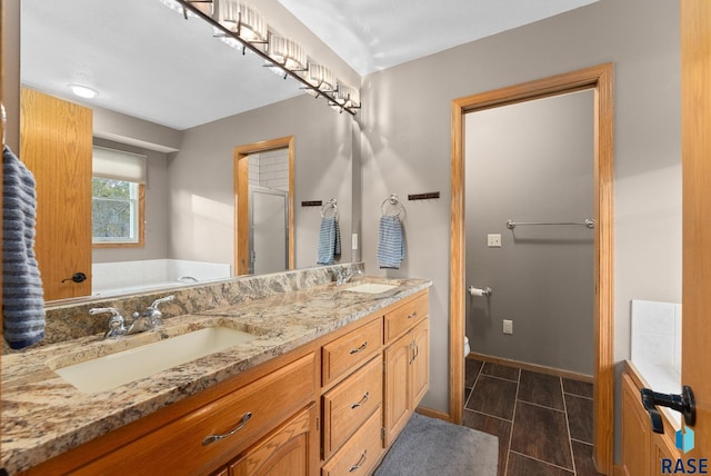 full bathroom with vanity, shower with separate bathtub, and toilet