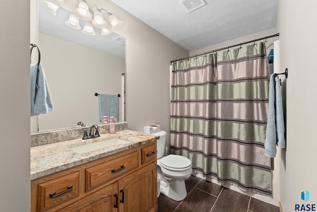 bathroom featuring vanity, toilet, a textured ceiling, and curtained shower